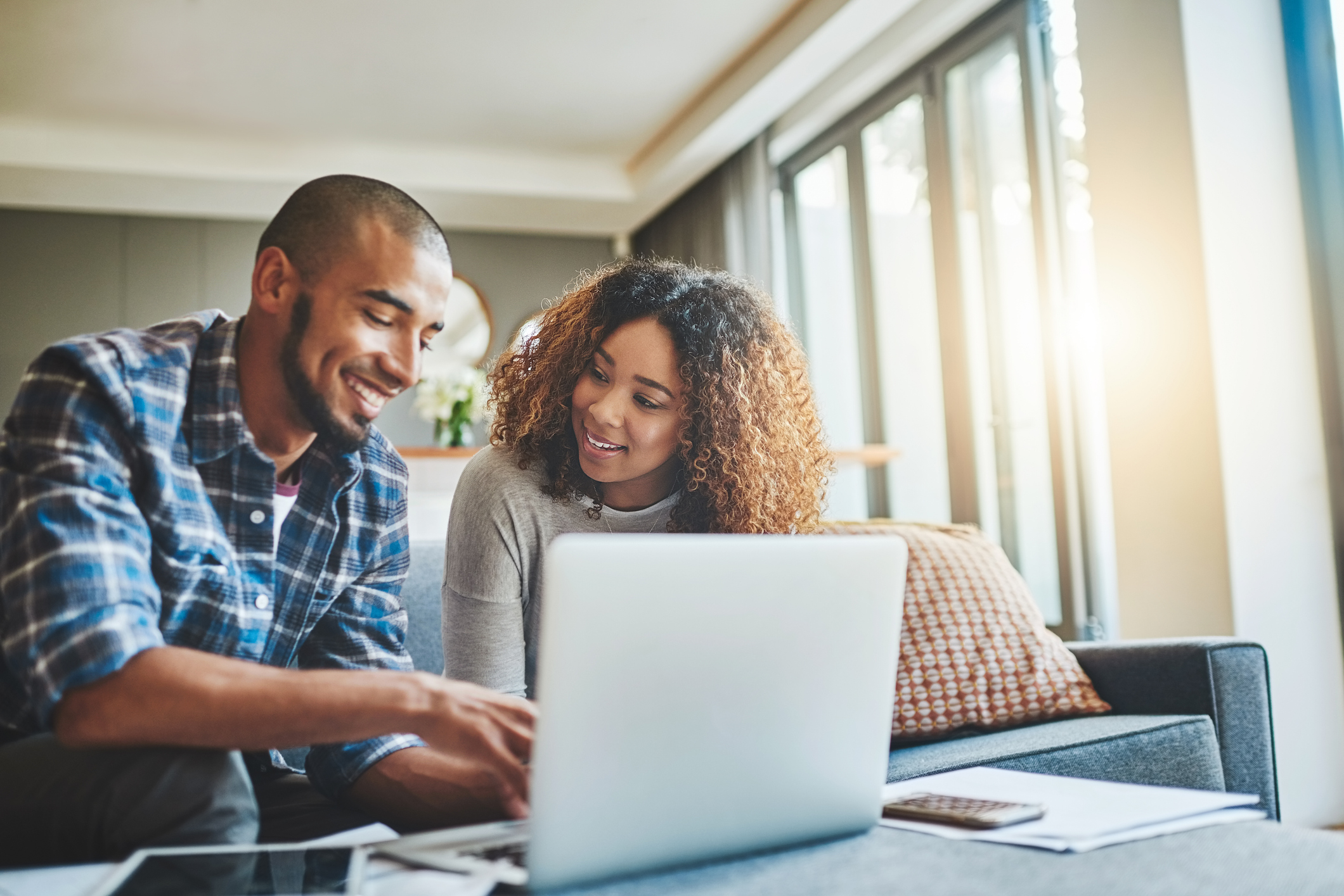 Young couple using a laptop to do their mortgage pre-qualification